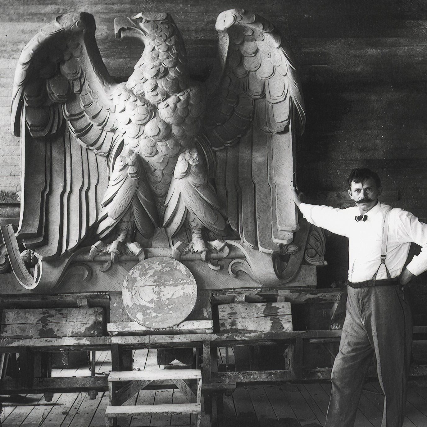 A worker poses with a giant, terra-cotta eagle figure. One of California's most famous art forms and a key part of the arts and crafts movement, terra cotta tile were championed by two important California Masons.
